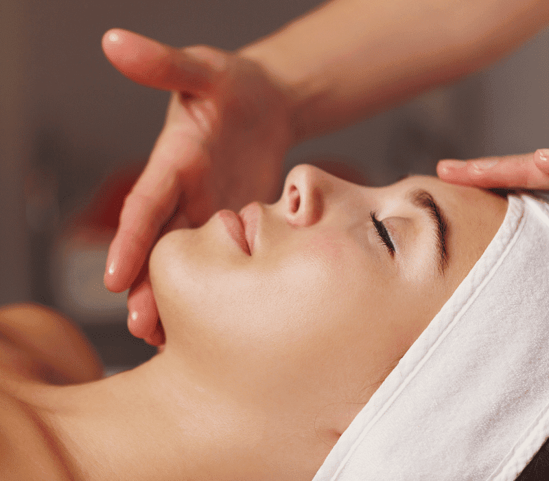 Person receives a relaxing facial massage with a towel wrapped around their head.